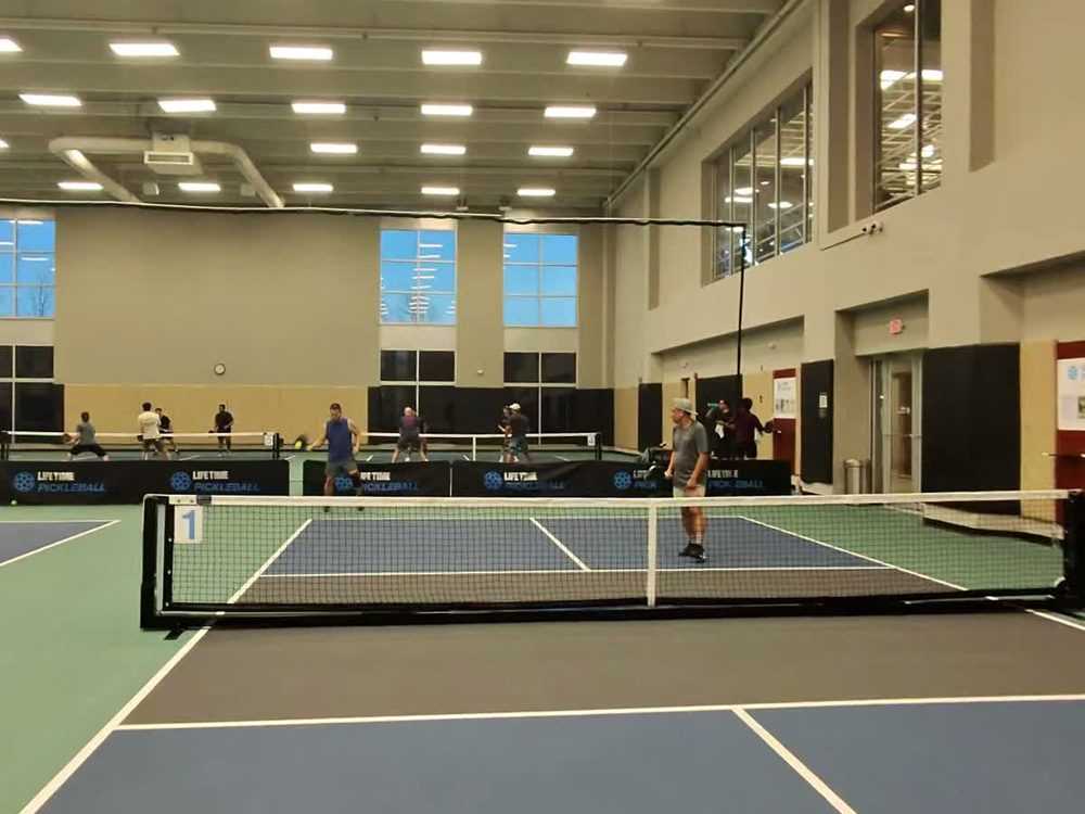 An indoor pickleball court mid-game.